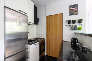 a kitchen with a refrigerator and a stove at Labo Apartment Karmelicka in Warsaw