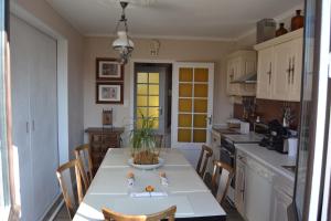 a kitchen with a white table and chairs in it at Pavillon de Lubéron in Lauris