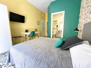 a bedroom with a bed with green and yellow walls at Pensión Alicante San Nicolás in Alicante