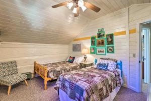1 dormitorio con 2 camas y 1 silla en una habitación en Riverfront Idyllic Lansing Home with Porch!, en Lansing
