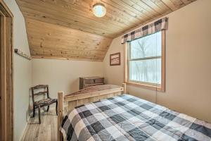 ein Schlafzimmer mit einem Bett, einem Fenster und einem Stuhl in der Unterkunft Cozy Birchwood Retreat on UTV Trail with Hot Tub! in Birchwood