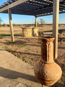 een grote vaas zittend op een stoep bij The White House at SF Ranch in Comanche