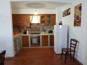 een keuken met een koelkast en een tafel en stoelen bij Appartamento Puccini in Fasano