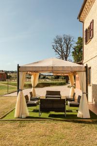 a gazebo with couches and chairs under it at Agriturismo Casale San Lorenzo in San Lorenzo in Campo