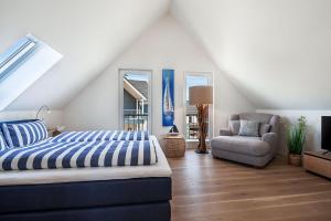 ein Schlafzimmer mit einem Bett und einem Stuhl in der Unterkunft NordseeResort Büsum Ferienhaus 1 Beach House in Büsum