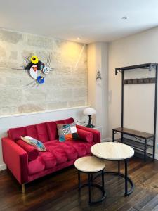 Lysbed - Le Pilori في أنجيه: غرفة معيشة مع أريكة حمراء وطاولتين