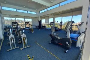 un gimnasio con varias cintas de correr y máquinas elípticas en Algarrobo Laguna Bahía Espectacular Departamento, en Algarrobo