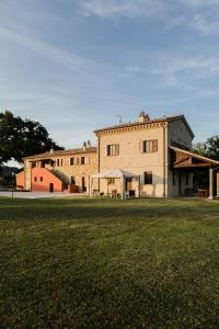 a large building with a grass field in front of it at Agriturismo Casale San Lorenzo in San Lorenzo in Campo