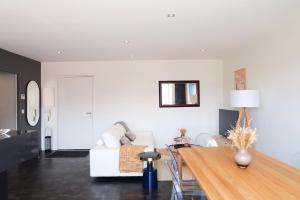 uma sala de estar com um sofá branco e uma mesa em Magnifique appartement, en hyper centre, avec terrasse et place de parking em Biarritz
