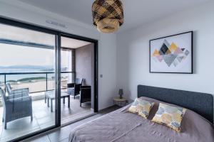 une chambre avec un lit et une grande fenêtre en verre dans l'établissement Le Sillage de Pietrosella, à Pietrosella