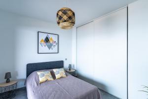 une chambre avec un lit et un mur bleu dans l'établissement Le Sillage de Pietrosella, à Pietrosella