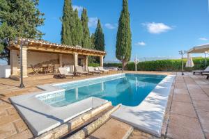 a swimming pool in a yard with a house at Villa Son Valentí in Sa Pobla