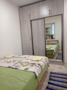 a bedroom with two beds and a mirror at Julia's Place - Apartment, Garden & BBQ in Vagharshapat