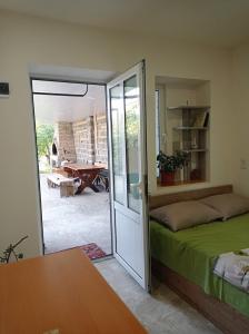 a bedroom with a bed and a sliding glass door at Julia's Place - Apartment, Garden & BBQ in Vagharshapat