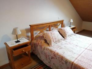 a bedroom with a bed and two lamps on tables at Recantos do Castanheiro in Porto Moniz