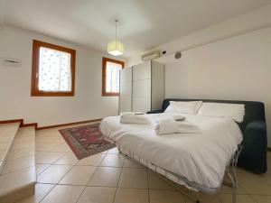 1 dormitorio con 1 cama grande y toallas. en Blue Apartment Conselve, en Conselve