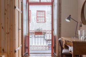 an open door to a balcony with a desk at The Poets Inn in Porto