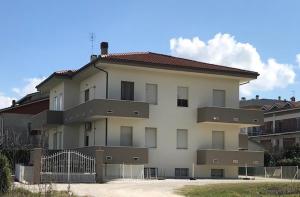 a large white building with a fence in front of it at Affittacamere AL 30 in Marzocca di Senigallia