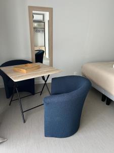 ein Schlafzimmer mit einem Tisch, einem Stuhl und einem Bett in der Unterkunft Chambre privatisée L’Ermitage vue sur la mayenne in Château-Gontier