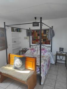 - une chambre avec un lit et un banc dans l'établissement Ático Arinaga con vistas , jacuzzi , terraza y barbacoa, à Arinaga