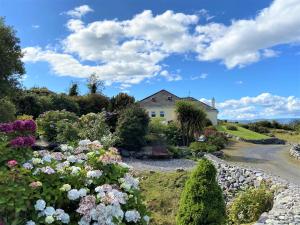 a house in the middle of a garden with flowers at Connemara Haven Bed and Breakfast in Oughterard