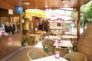 un ristorante all'aperto con tavoli, sedie e ombrellone di Hostal Restaurante La Muralla a Cañete