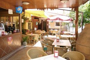 an outdoor restaurant with tables and chairs and an umbrella at Hostal Restaurante La Muralla in Cañete