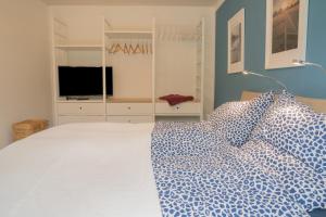 a bedroom with a white bed and a television at Ferienhaus Naturwerk in Schwarzach am Main