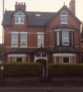 a red brick house with a white door at Bouvrie Guest House in Hereford