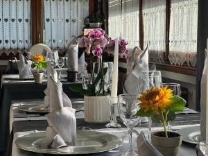 una mesa con platos, vasos y flores. en Aurora, en Castione della Presolana