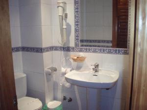 a small bathroom with a sink and a toilet at Hostal Restaurante La Muralla in Cañete