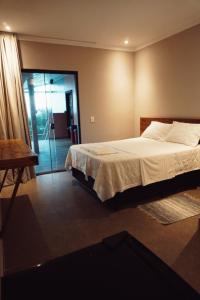1 dormitorio con 1 cama y puerta corredera de cristal en Graffi Beach House, en Florianópolis