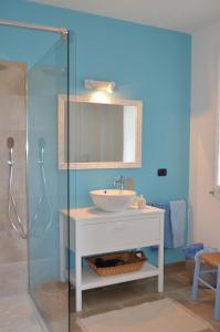 a bathroom with a sink and a glass shower at Gaia e Levante in Piazza