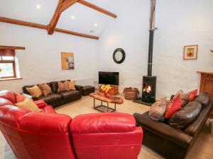 sala de estar con sofás de cuero y chimenea en 2 Fenton Home Farm en Haverfordwest