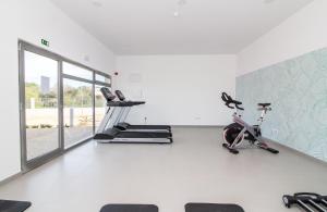 einen Fitnessraum mit zwei Laufbändern und zwei Heimtrainern in der Unterkunft Green Apartment - Luxurious & Pool & Garden & Playground & Garage in Albufeira