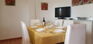 mesa de comedor con mantel amarillo y TV en Alojamiento Rural el Respiro "Calma", en Benaocaz