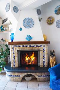 a fireplace in a living room with blue and white tiles at Villa Due Golfi in Colli di Fontanelle