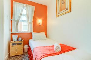 um pequeno quarto com 2 camas e uma janela em The Sandringham Court Hotel & Sports Bar-Groups Welcome here-High Speed Wi-Fi em Blackpool