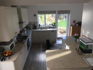 a kitchen with white cabinets and a large window at No Car Needed in Christchurch
