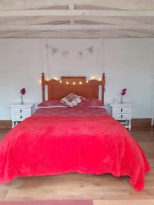 a bedroom with a red bed with two white tables at Hidden Valley Andalucia in Alora