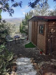 a small shed with a table and two chairs at Hidden Valley Andalucia in Alora