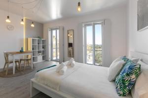 Un dormitorio blanco con una cama grande y una mesa en Calçada 14 en Óbidos