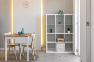 a dining room with a table and a white book shelf at Calçada 14 in Óbidos