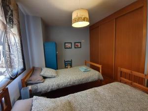 1 Schlafzimmer mit 2 Einzelbetten und einer Lampe in der Unterkunft Casa rural en la Sierra Norte de Madrid in Manjirón