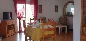 a dining room with a table with a yellow table cloth at Alojamiento Rural El Respiro "Brisa" in Benaocaz +16 photos