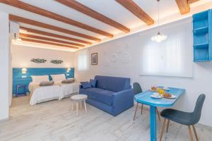 CASA AZUL - Boutique Apartments by Casa del Patio في إِستيبونا: غرفة معيشة مع أريكة زرقاء وسرير
