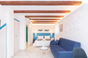 a living room with a blue couch and a bed at CASA AZUL - Boutique Apartments by Casa del Patio in Estepona