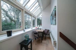 a room with a window and a table and chairs at Villa Near The Beach in Wassenaar