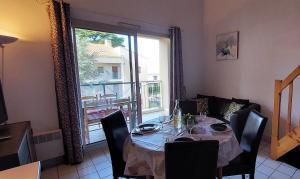 uma sala de jantar com uma mesa e uma grande janela em APPARTEMENT AU CALME AVEC PISCINE ET PARKING dans résidence securisée em Saint-Jean-de-Monts