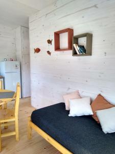 1 dormitorio con 1 cama, mesa y nevera en Nio de Baixo, en La Pedrera